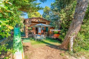 a log cabin with a table and chairs and an umbrella at Chalet gite in Saint-Paulet-de-Caisson