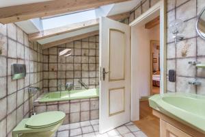 a bathroom with a toilet and a sink and a tub at Großes Ferienhaus mit Bergblick in Unterwössen +29 photos