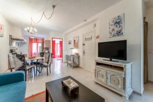 ein Wohnzimmer mit einem Flachbildfernseher auf einem Tisch in der Unterkunft Le Taulignan in Vaison-la-Romaine