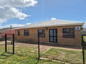 a fence in front of a brick house at Remmys Place in Hawston
