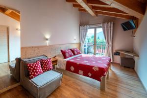 a bedroom with a red bed and a chair at Alpen Chalet - Charme Mountain Hotel - in Schilpario +70 photos