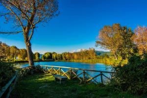 a bench sitting next to a fence next to a lake at Camping Village Punta Navaccia in Tuoro sul Trasimeno