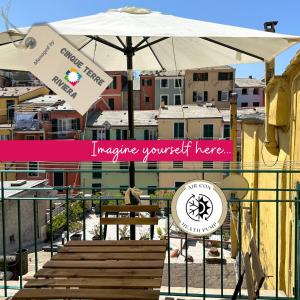 a sign with an umbrella and a bench and some buildings at Ca' Bea with AC and Terrace in Vernazza