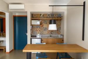 a kitchen with a wooden table and blue chairs at QSB - Quinta Santa Bárbara in Pirenópolis