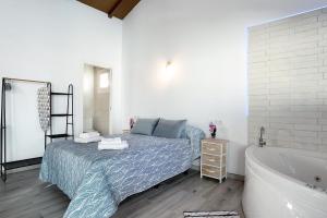 a bedroom with a bed and a bath tub at La Teja 3 - Solo Familias in Vejer de la Frontera +27 photos