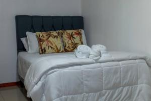 Una cama blanca con dos animales de peluche. en Apartamento Lantanas, en Palma