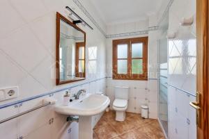 a bathroom with a sink and a toilet and a mirror at Casa en Montferrutx in Colonia de Sant Pere