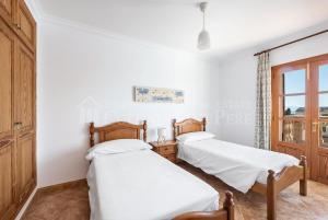 two beds in a room with a window at Casa en Montferrutx in Colonia de Sant Pere