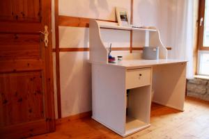 a white desk in a room with a shelf at Wohnen im schönen Bauernhaus in Beckingen +21 photos
