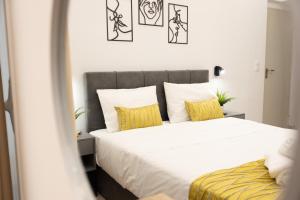 Un dormitorio con una gran cama blanca con almohadas amarillas. en Athens Luxury Penthouse, en Atenas 67 fotos más