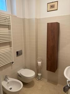 une salle de bain avec des toilettes blanches et un lavabo dans l'établissement Appartamento Verde Golf, à Miglianico 24 autres photos