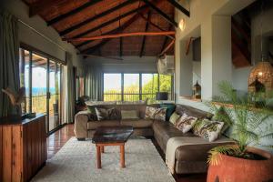 a living room with a couch and a table at Tree House Villa in Praia do Tofo