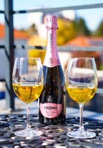 Una botella de vino y dos copas en una mesa en Hotel Fantazia Oradea - Self Check In & Out, en Oradea