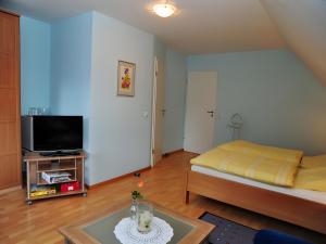 a small living room with a bed and a tv at Kuryhof in Simonswald