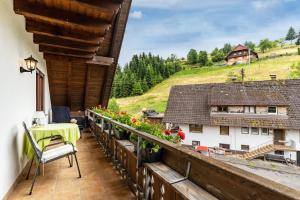 a balcony of a house with a table and flowers at Furtwengler in Oberharmersbach