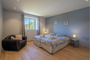 a bedroom with a bed and a chair and a window at Le Mas de l'Olivier in Plan-dʼOrgon +25 photos