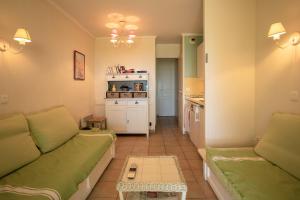 un salon avec un canapé et une cuisine dans l'établissement Restanques de Saint Tropez - arums, à Grimaud 17 autres photos