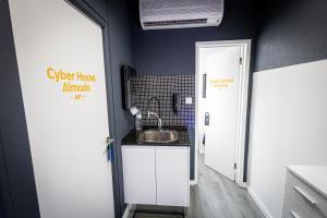 Una pequeña cocina con fregadero en una habitación. en CyberHostel Almada, en Almada