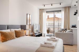 - une chambre blanche avec un grand lit et un canapé dans l'établissement Yamas Urban Living Olympia Suites, à Limassol