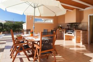 a patio with a table and chairs with an umbrella at Ca na Catalina in Sant Jordi