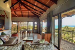 a living room with a couch and a table at Tree House Villa in Praia do Tofo