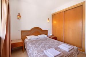 a bedroom with a bed with two towels on it at Algarve apartments L in Olhos de Água