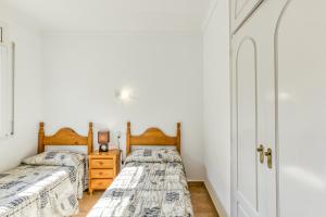 two beds in a bedroom with white walls at Villa Allegra in L'Escala +20 photos