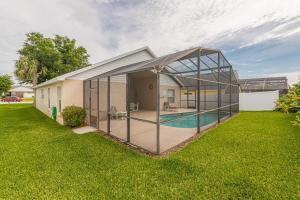 a glass house with a pool in the yard at Safari Lodge in Orlando