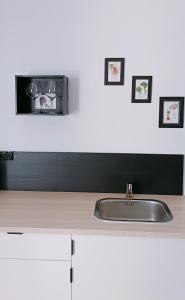 eine Küchentheke mit Spüle und zwei Bildern an der Wand in der Unterkunft Perfect Studio - au calme avec terrasse, jardin, piscine in Libourne