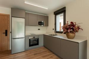 a kitchen with a white refrigerator and a counter at Apartamentos Duratón in San Miguel de Bernúy