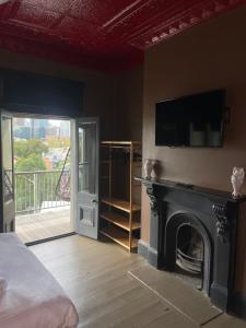 a bedroom with a fireplace with a tv on the wall at Glengarry Castle Hotel in Sydney