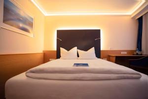 łóżko z dwiema poduszkami w pokoju w obiekcie Hotel Bavaria Brehna w mieście Brehna