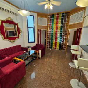 a living room with red couches and stained glass windows at Qurum Heights Hotel in Muscat