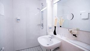 biała łazienka z umywalką i prysznicem w obiekcie Hotel Bavaria Brehna w mieście Brehna +20 zdjęć