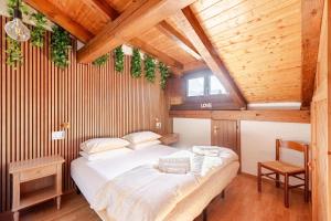 ein Schlafzimmer mit einem großen Bett in einer Holzdecke in der Unterkunft Val di Sole Apartment in Monclassico + 20 Fotos
