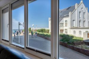 a window with a view of a street and a building at Alte Teestube 69 2 Raum in Norderney