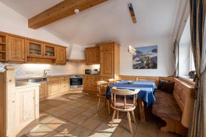 a kitchen with wooden cabinets and a table and chairs at Penthouse Appartement in Kirchberg in Tirol