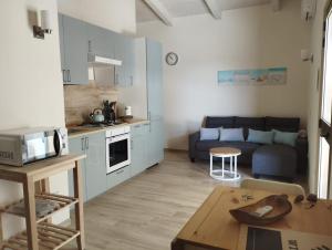 a kitchen and a living room with a couch and a table at Casa Camari in Policoro