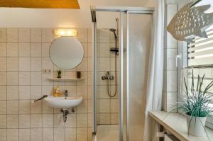 ノルトダイヒにあるFerienhaus Diekster - Obergeschossのシャワーと洗面台付きのバスルーム +12枚の写真