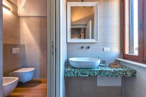 a bathroom with a sink and a toilet and a mirror at Casa Carol in Marina di Campo +18 photos