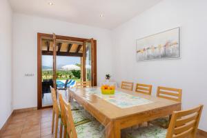 a dining room with a wooden table and chairs at Can Terres - Baladre in Artá