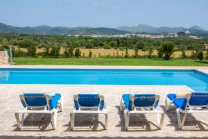 a group of chairs sitting next to a swimming pool at Can Terres - Baladre in Artá