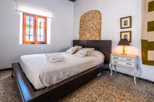 a bedroom with a bed and a table with a lamp at La Casa del Agua in Vejer de la Frontera