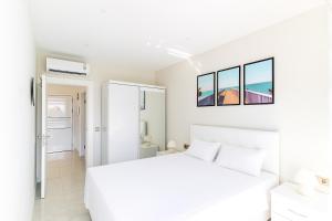 a white bedroom with a white bed and two windows at The Blue Tide - 1 Bedroom Apartment - All Bills Included in Alanya +41 photos