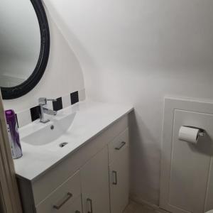 a bathroom with a white sink and a mirror at Cozy spacious room in Sole Street