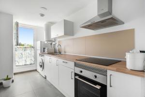 a kitchen with white cabinets and a sink at Lopimar Bonito in Canet de Berenguer