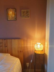 Un dormitorio con una cama y una lámpara sobre una mesa. en La Chambre de la Ferme du Clos Giot, en Saint-Vaast-la-Hougue 1 foto más