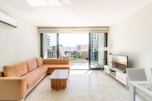 a living room with a couch and a tv at The Blue Tide - 1 Bedroom Apartment - All Bills Included in Alanya