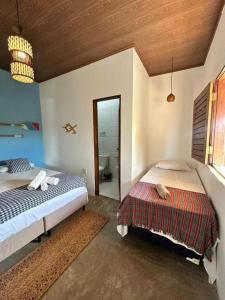 a bedroom with two beds and a bathroom at Maraville Angels BG - Charme, aconchego e localização privilegiada in Barra Grande