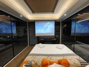 a room with a bed and a projection screen at Sunny Pavilion Thoddoo in Thoddoo